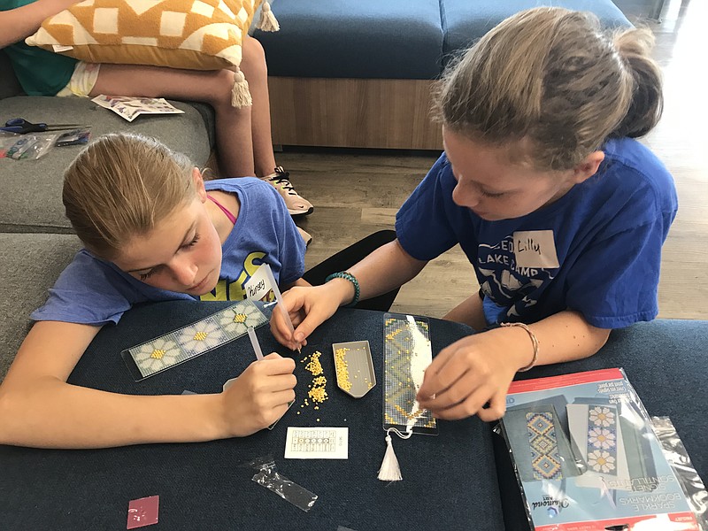 Staff photo by Emily Crisman / Kinsey Grow, 12, and Lilly Garrett, 11, from left, create sparkle bookmarks during a summer program at the Claudia Nance Rollins Youth Center in Ringgold, Ga. The center is holding a grand opening event Aug. 7 from 4-8 p.m.