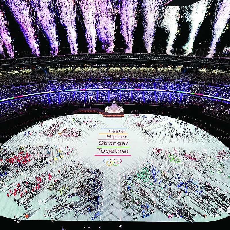 Photo by Morry Gash of The Associated Press / Athletes are seen with fireworks during the opening ceremony at the Olympic Stadium at the 2020 Summer Olympics on July 23, 2021, in Tokyo.