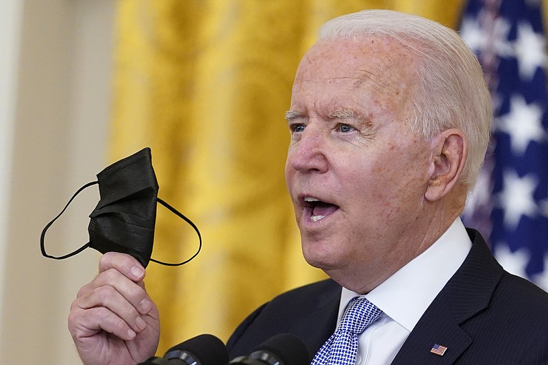 President Joe Biden holds up a mask as he announces from the East Room of the White House in Washington, Thursday, July 29, 2021, that millions of federal workers must show proof they've received a coronavirus vaccine or submit to regular testing and stringent social distancing, masking and travel restrictions in an order to combat the spread of the coronavirus. (AP Photo/Susan Walsh)