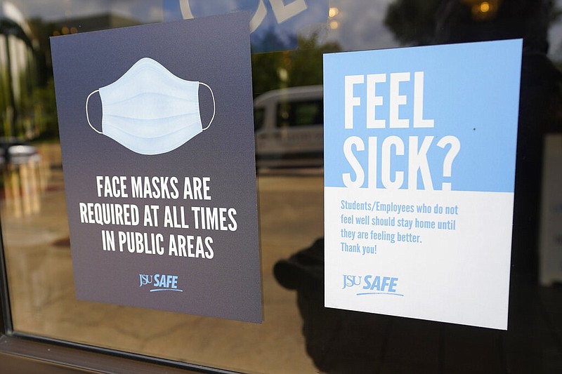 Face mask requirements are posted at the various entrances at the Rose E. McCoy Auditorium where COVID-19 vaccinations are being offered on the Jackson State University campus in Jackson, Miss., Tuesday, July 27, 2021. The university has similar signage posted throughout the campus. The Centers for Disease Control and Prevention announced new recommendations that vaccinated people return to wearing masks indoors in parts of the U.S. where the coronavirus is surging and also recommended indoor masks for all teachers, staff, students and visitors to schools, regardless of vaccination status. (AP Photo/Rogelio V. Solis)