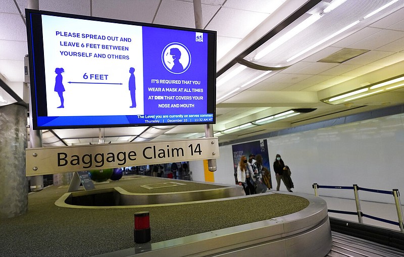 In this Dec. 10, 2020, file photo, an electronic sign warns travelers to maintain social distance in the terminal of Denver International Airport in Denver. About one-fifth of flight attendants say they've gotten into a physical incident with a passenger this year. That's according to a survey by their union. The Association of Flight Attendants says it wants people who act up during flights to face criminal prosecution — not just fines. Airlines have reported more than 3,600 cases of unruly passengers this year. Disputes over face masks are the most common trigger. Federal rules require face masks on planes until mid-Sept (AP Photo/David Zalubowski, File)