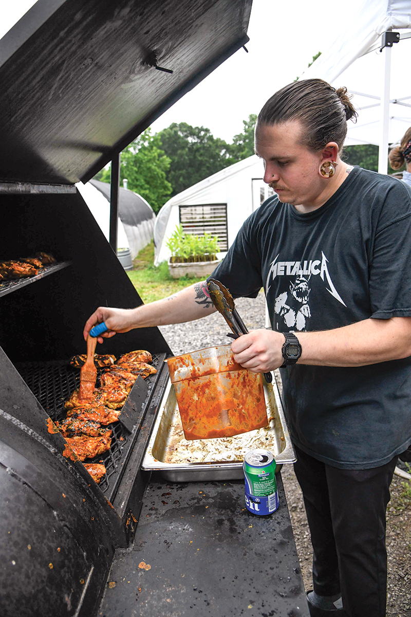Photo by Mark Gilliland / Tyler Grayko grills chicken.