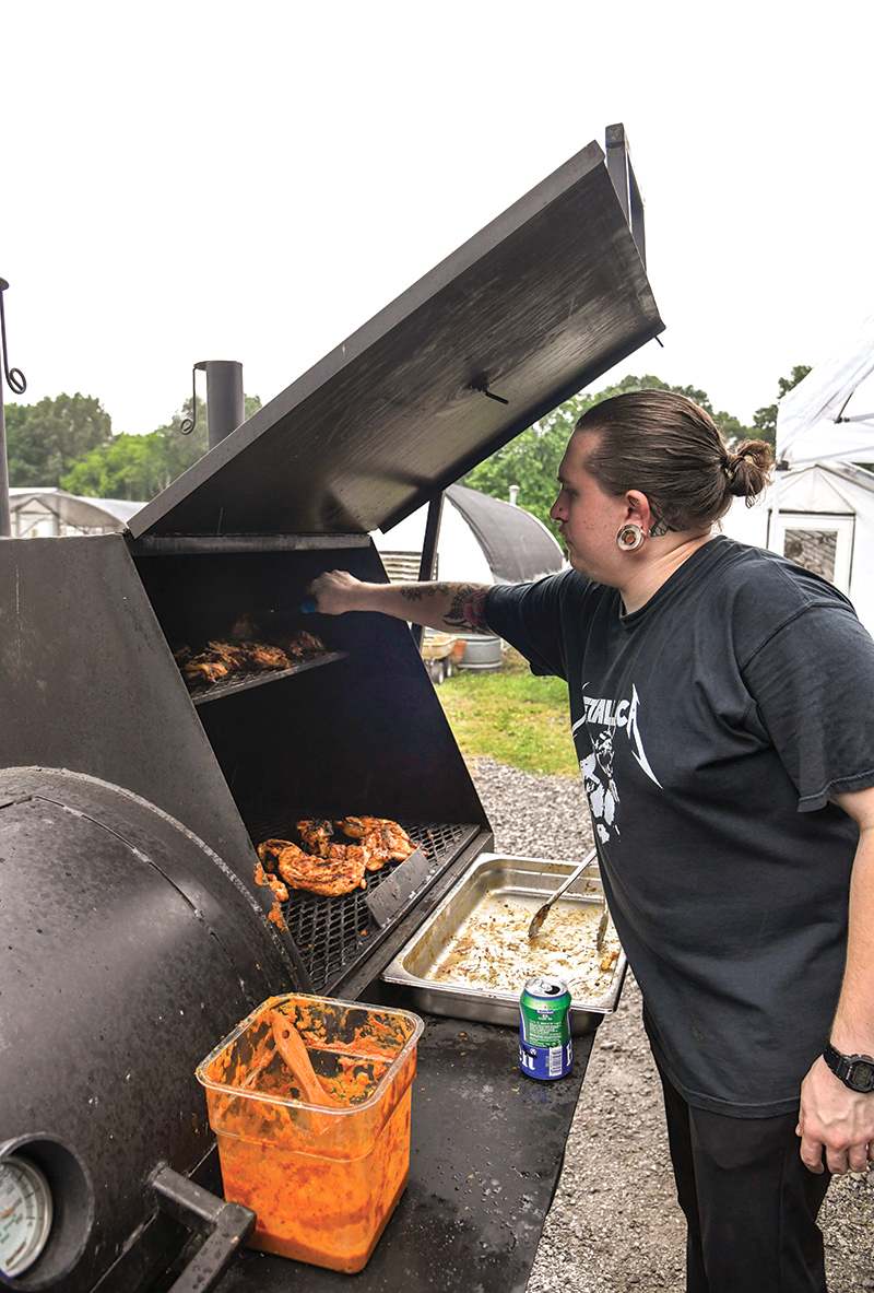 Photo by Mark Gilliland / Tyler Grayko grills chicken.