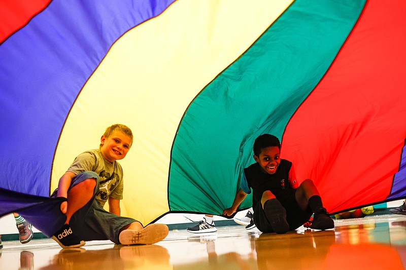 Staff photo by Troy Stolt / Grayson Krasnicki, 9, and Mickah Buggs, 9, play in a parachute during Summer Reach at East Brainerd Elementary on Tuesday, July 27, 2021 in Chattanooga, Tenn.