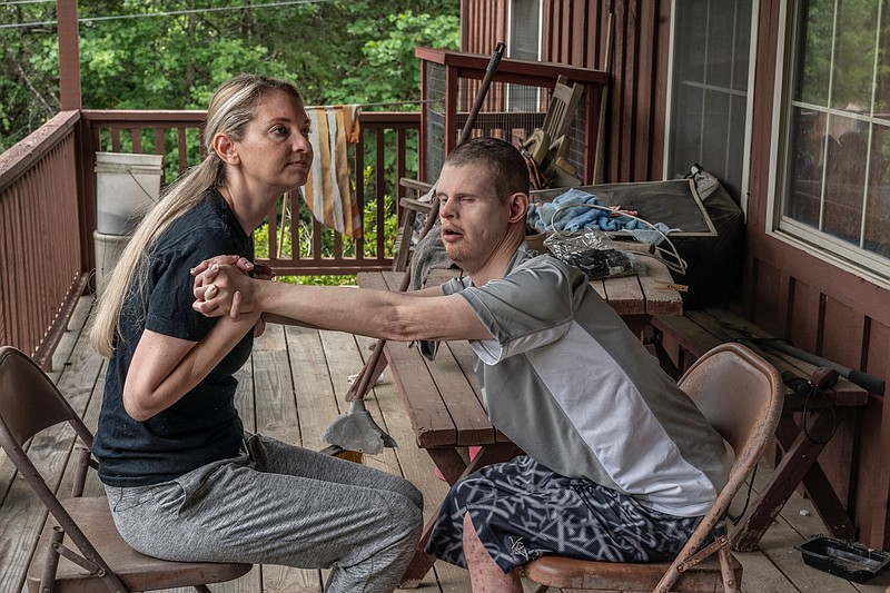 Drama Bryant, 38, with her brother Jay, 32, on the front porch of their family's home in Greene County. She is his primary caretaker. (Photo: John Partipilo)