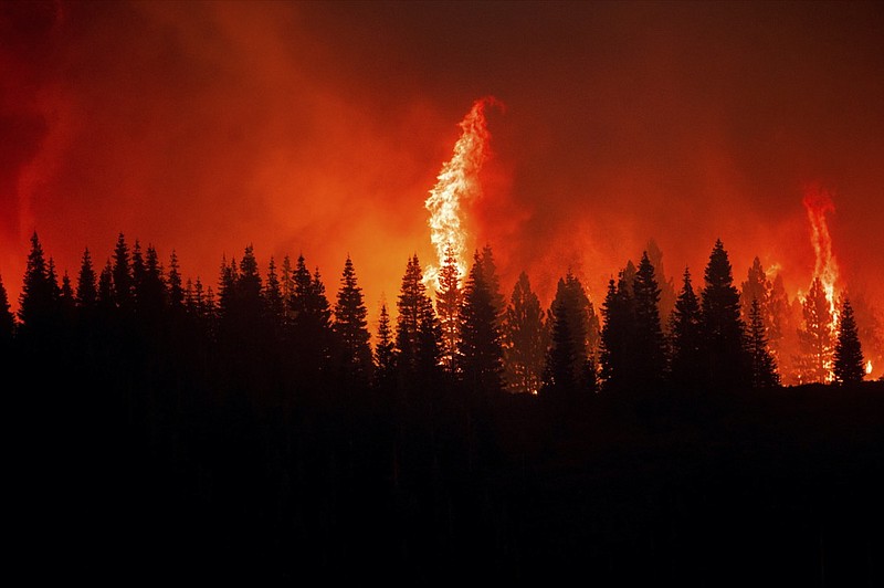 Flames from the Dixie Fire crest a hill in Lassen National Forest, Calif., near Jonesville on Monday, July 26, 2021. (AP Photo/Noah Berger)