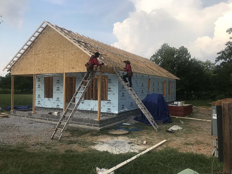 Photo by Dave Flessner / Workers help frame a new house being built on Canary Circle in Alton Park by Habitat for Humanity. The house is the next home to feature energy savings features to help cut utility bills for its owner.