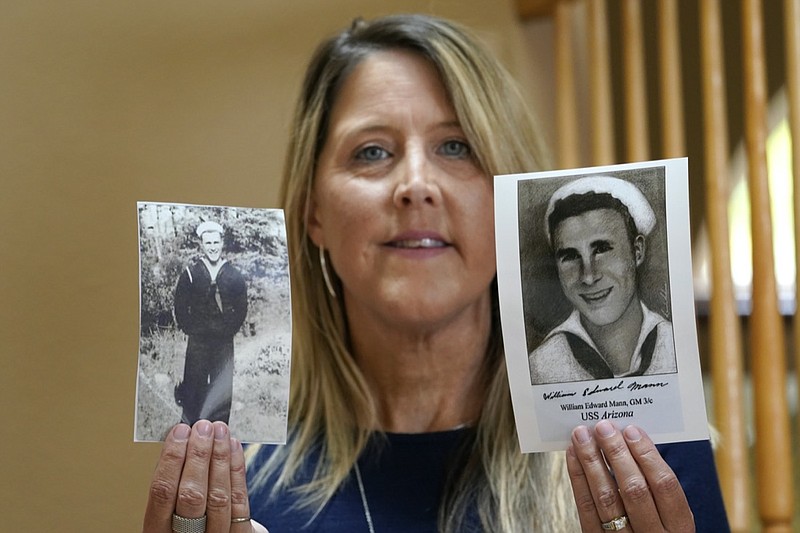 Teri Mann Whyatt displays photos of her uncle, William Edward Mann, who died on the USS Arizona during the bombing of Pearl Harbor, at her home Wednesday, July 14, 2021, in Newcastle, Wash. In recent years, the U.S. military has taken advantage of advances in DNA technology to identify the remains of hundreds of sailors and Marines who died in the 1941 bombing of Pearl Harbor and has sent them home to their families across the country for burial. The remains of 85 unknowns from the USS Arizona, which lost more men during the attack than any other ship, haven't received this treatment, however. (AP Photo/Elaine Thompson)