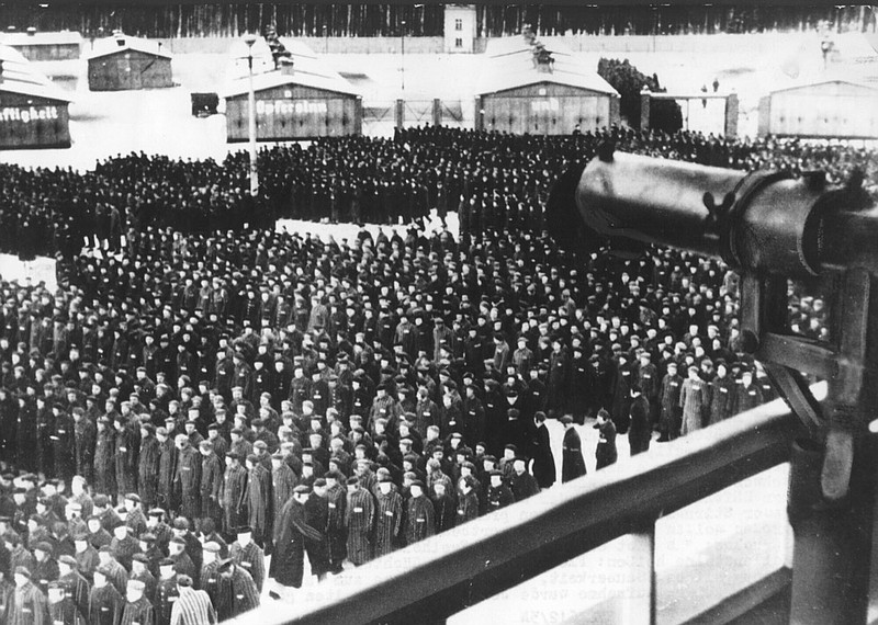 FILE - This undated file photo shows a roll call, in the early morning or late evening hours, on the roll call square in front of the camp gate of the Nazi concentration camp Sachsenhausen in Oranienburg on the outskirts of Berlin, Germany. In the foreground on the tower a machine gun pointed at the prisoners. A German court has set a trial date for a 100-year-old man who is charged with 3,518 counts of being an accessory to murder on allegations he served during World War II as a Nazi SS guard at the Sachenhausen camp. (AP Photo, file)