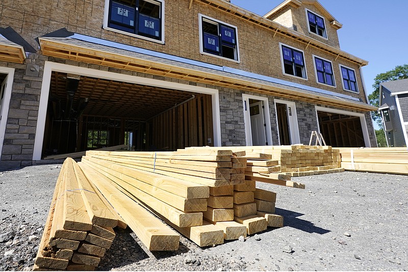 FILE - In this June 24, 2021 file photo, lumber is piled at a housing construction site in Middleton, Mass. Wood prices have skyrocketed over the last year, leaving would-be home renovators deciding whether to wait out the high costs or move forward on a project that's more expensive than it would have been a year ago. (AP Photo/Elise Amendola)
