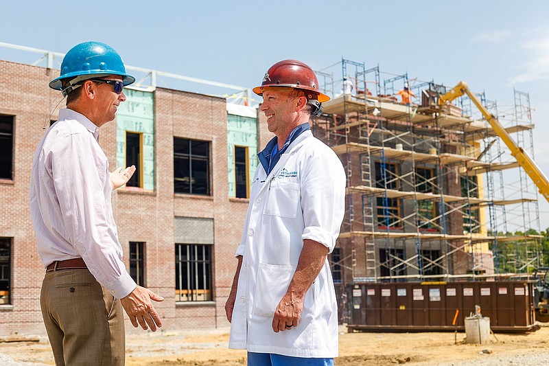 Staff photo by Troy Stolt / Bob Elliott, left, president of Noon Development, and Dr. Jay Jolley, an investor in the future Riverfront Surgery Center, talk at the construction site of the facility on Riverfront Parkway.