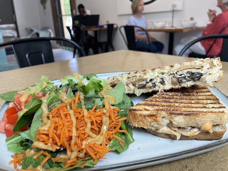 Photo by Anne Braly / The Real Roots Reuben sandwich, left, is served with a generous side salad. The sandwich, made with seitan, mushrooms, imitation mozzarella cheese, grilled onions and sauerkraut, is served panini style.