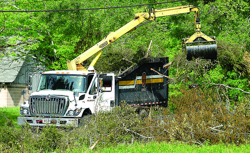 Staff file photo by Robin Rudd / A Chattanooga Department of Public Works employee fills a brush truck as storm debris from the April 12th EF3 tornado is removed from along Davidson Road in East Brainerd in 2020. City workers would get a raise in Mayor Tim Kelly's budget.