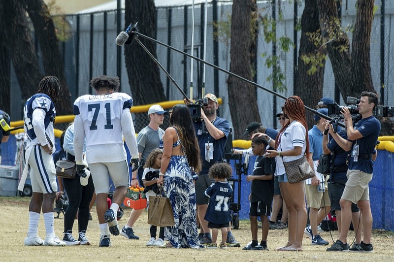 NFL Films crew shooting the "Hard Knocks" series films Dallas Cowboys defensive end Randy Gregory, left, and tackle La'el Collins (71) with their families after practice at the NFL football team's training camp in Oxnard, Calif., Wednesday, July 28, 2021. (AP Photo/Michael Owen Baker)


