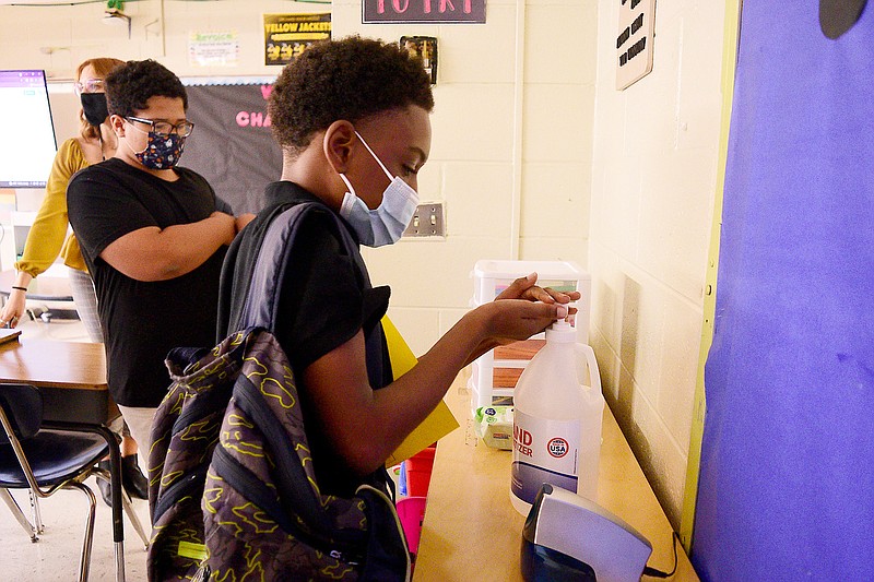 Staff Photo by Robin Rudd /  Students use hand sanitizer in Melanie Raybon's Sixth Grade classroom.  Orchard Knob Middle School started the 2021-2022 school year under a Hamilton County Schools system wide mask mandate on August 9, 2021, because of the surge in the Delta variant of the Coronavirus.