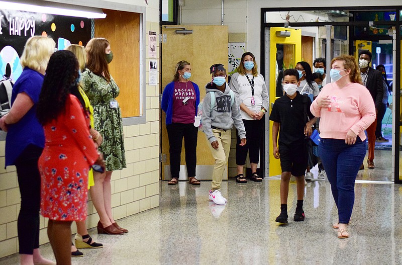 Staff Photo by Robin Rudd /  Members of the Midtown Learning Community, left, greet students and parents on the first day.  Orchard Knob Middle School started the 2021-2022 school year under a Hamilton County Schools system wide mask mandate on August 9, 2021, because of the surge in the Delta variant of the Coronavirus.