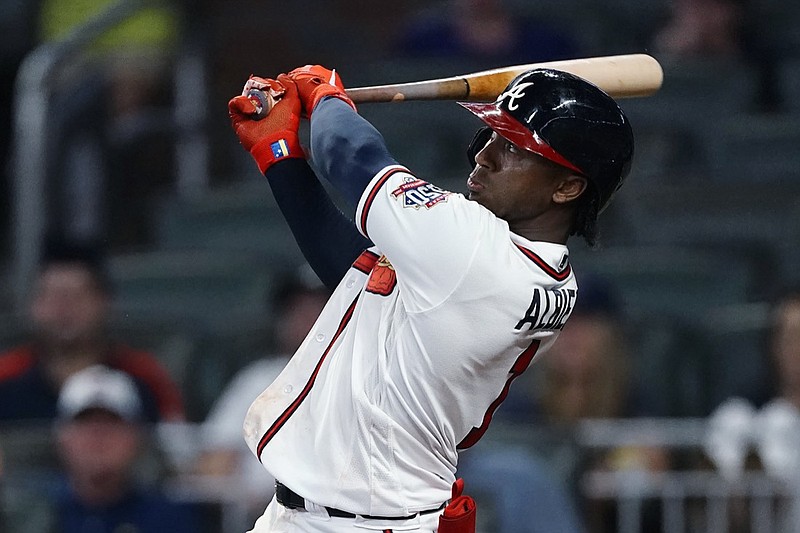 Atlanta Braves' Ozzie Albies follows through on a three-run home run in the 11th inning of the team's baseball game against the Cincinnati Reds on Wednesday, Aug. 11, 2021, in Atlanta. The Braves won 8-6. (AP Photo/John Bazemore)