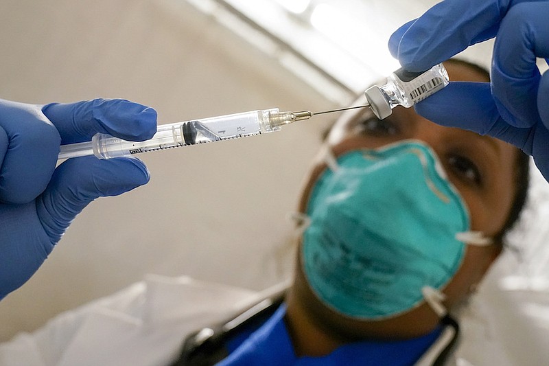 In this Jan. 15, 2021, file photo, Dr. Yomaris Pena, Internal Medicine Physician with Somos Community Care at a COVID-19 extracts the Pfizer COVID-19 Vaccine out of a vial at a vaccination site at the Corsi Houses in the East Harlem neighborhood of New York. U.S. health regulators have authorized extra doses of the COVID-19 vaccines in people with weakened immune systems to better protect them from the virus. The announcement Thursday, Aug. 12. by the Food and Drug Administration applies to millions of Americans who take immune-suppressing medicines because of organ transplants, cancer or other disorders.(AP Photo/Mary Altaffer, File)