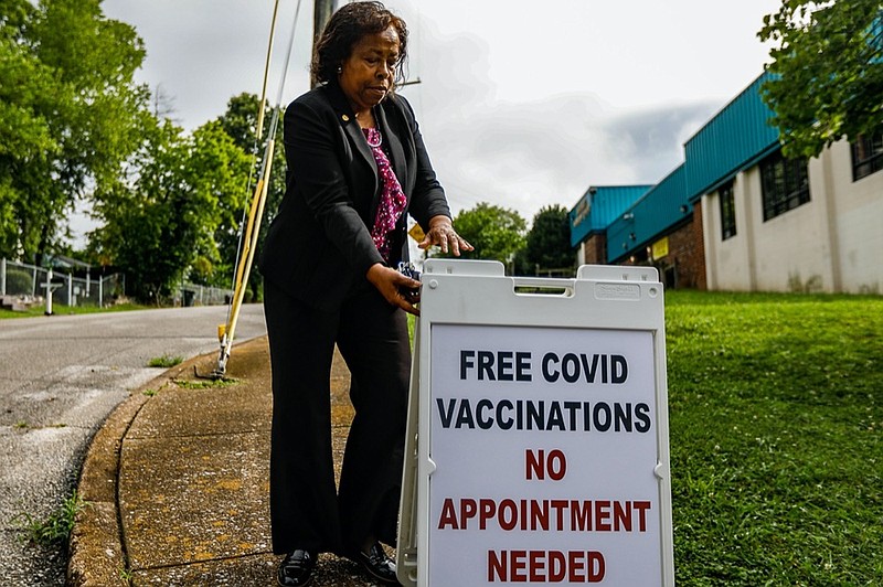 Staff photo by Troy Stolt / Mary Lambert, the new Director of Community Health for the city of Chattanooga, walks a sign that reads "Free COVID Vaccinations No Appointment Required to the corner of Moss drive and through street, just outside of Eastdale Community Center on Wednesday, July 14, 2021 in Chattanooga, Tenn. Lambert has set up an initiative to provide free COVID-19 vaccines at Community and YFD centers across the city. 