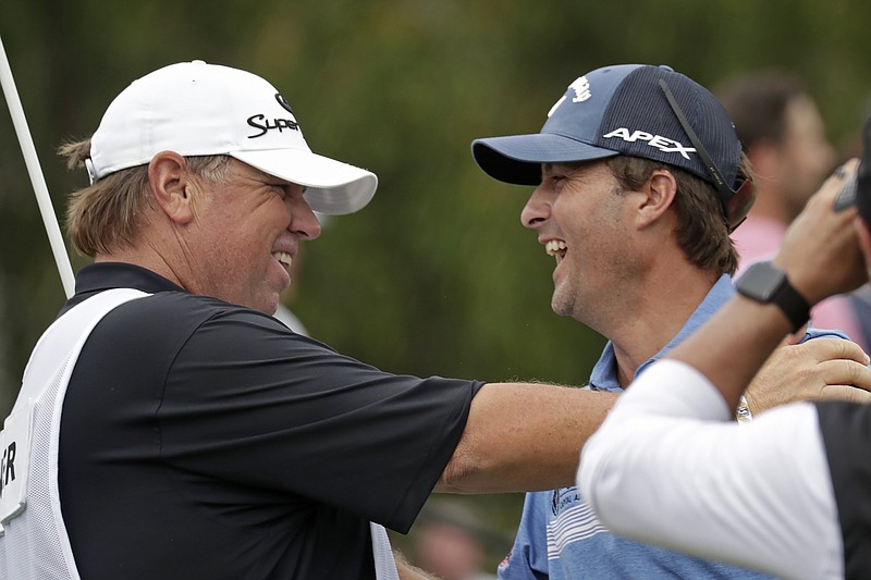 AP photo by Chris Seward / Kevin Kisner, right, celebrates with caddie Duane Bock on Sunday after sinking a birdie putt on the second playoff hole at Sedgefield Country Club to win the PGA Tour's Wyndham Championship in Greensboro, N.C.