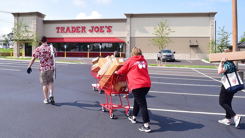 Staff Photo by Robin Rudd / Employees of the Trader Joe's carry supplies into the store in advance of the store's grand opening on Aug. 25.