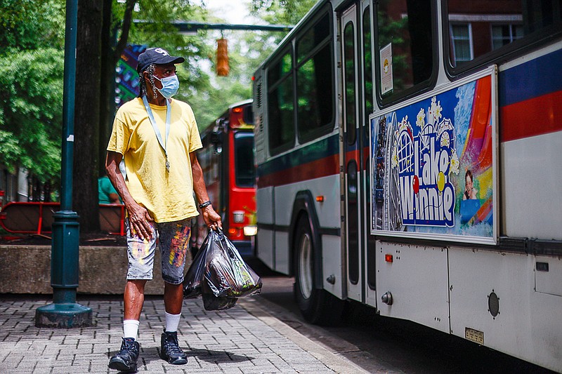 Staff photo by Troy Stolt / James Carlos Carter Jr. boards the CARTA line 21 bus on Market Street on Monday, Aug. 16, 2021, in Chattanooga, Tenn. The bus system will be reinstating fares for the first time since the spring of 2020.