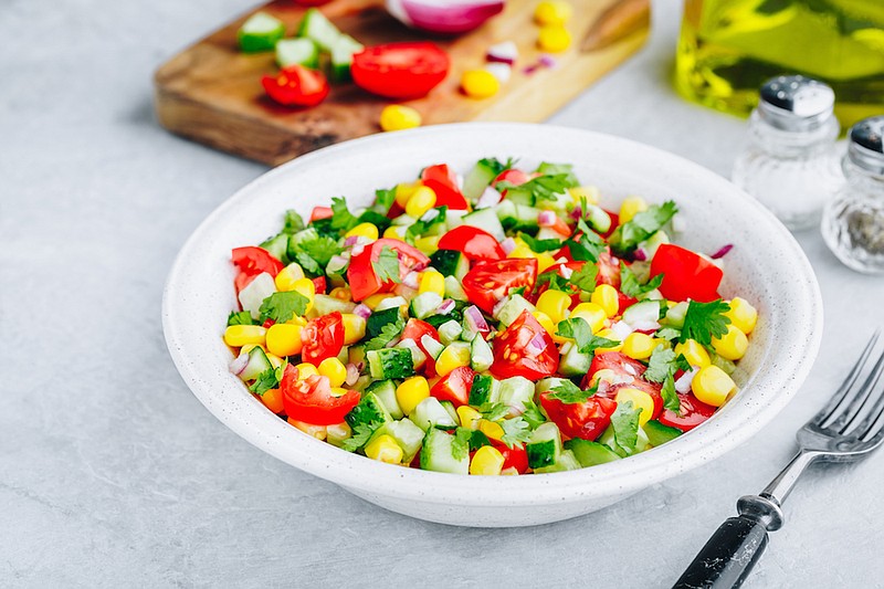 Fresh summer sweet corn salad bowl with tomatoes, cucumbers, red onions and parsley. / Photo credit: Getty Images/iStock/wmaster890