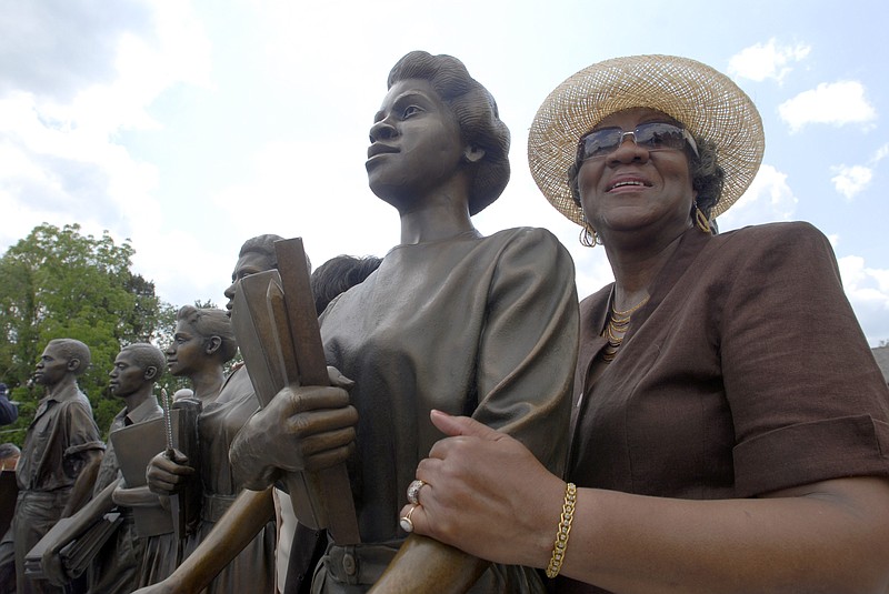Minnie Ann Dickey Jones, one of the "Clinton 12," the first students to attend a court-ordered desegregated school in the South, shows off the statue that depicts her as a teenager during a dedication ceremony for the statue, Thursday, May 17, 2007, in Clinton, Tenn. On their first day at Clinton High School on Aug. 27, 1956, the students walked down the hill from their neighborhood and passed hundreds of taunting, angry white people. The governor at the time sent troops to the small town outside Knoxville to uphold the law. (AP Photo/Knoxville News Sentinel, Clay Owen ) 