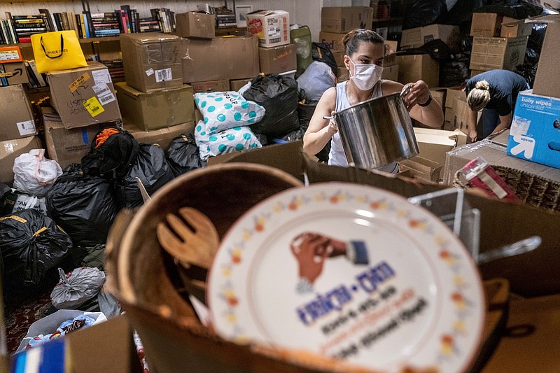 Photo by Andrew Harnik of The Associated Press / Milena Mijuskovic and other volunteers, receive, sort, and pack thousands of items donated to refugees resettling in the Washington region who are fleeing Afghanistan at Lapis, an Afghani restaurant in Adams Morgan neighborhood of Washington on Thursday, Aug. 19, 2021.