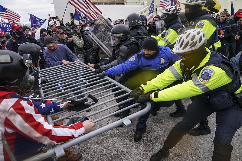 FILE - In this Jan. 6, 2021, file photo violent insurrectionists loyal to President Donald Trump hold on to a police barrier at the Capitol in Washington.