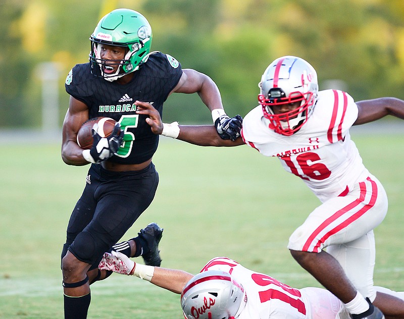 Staff photo by Robin Rudd /  East Hamilton's Jeremiah Flemmons breaks free from two Ooltewah defenders for a big gain Friday night during the season opener for both teams.