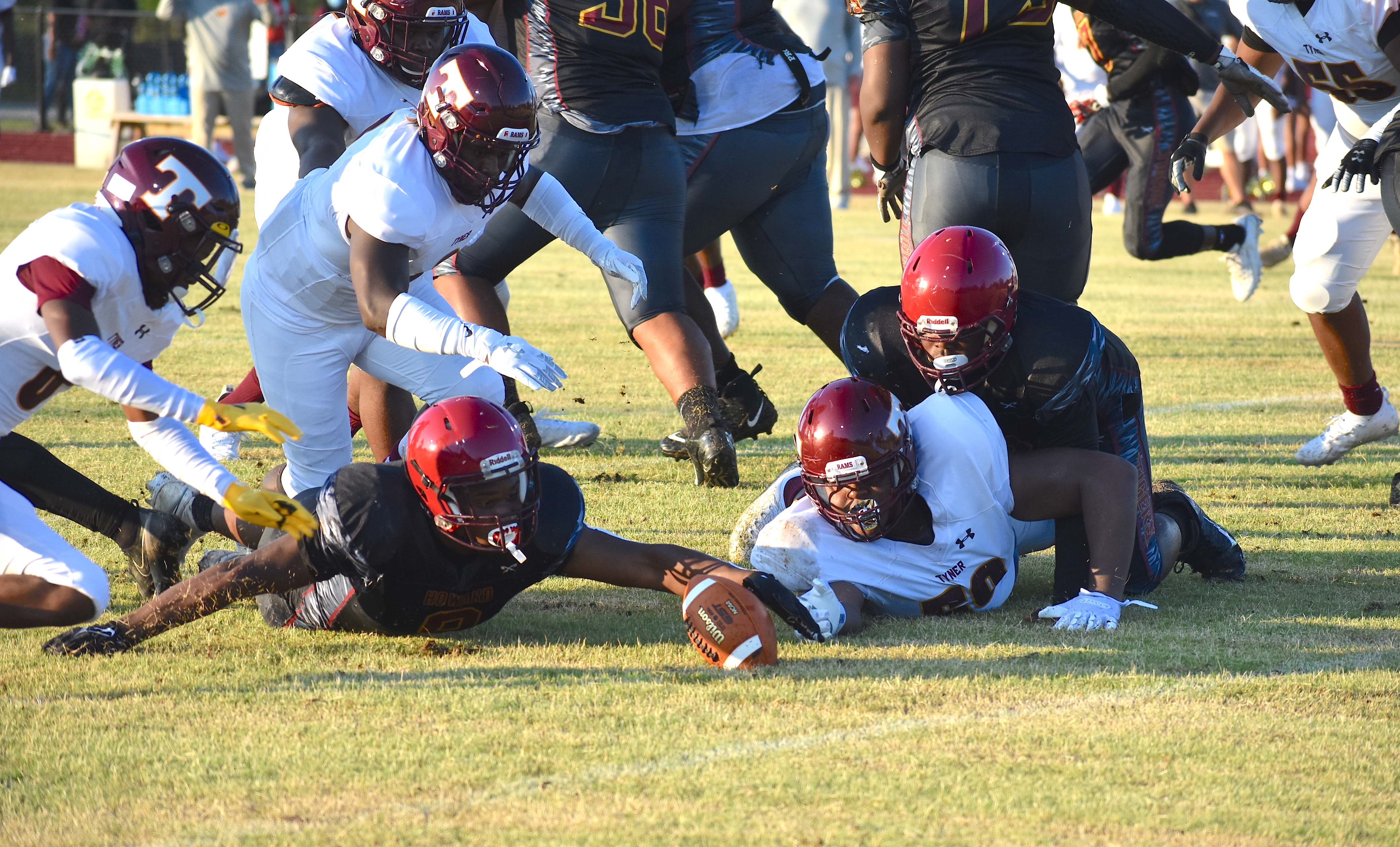 Staff photo by Patrick MacCoon / Tyner and Howard players reach for the loose ball during Friday night's season opener. The Rams led 20-0 at halftime and cruised to a road victory.