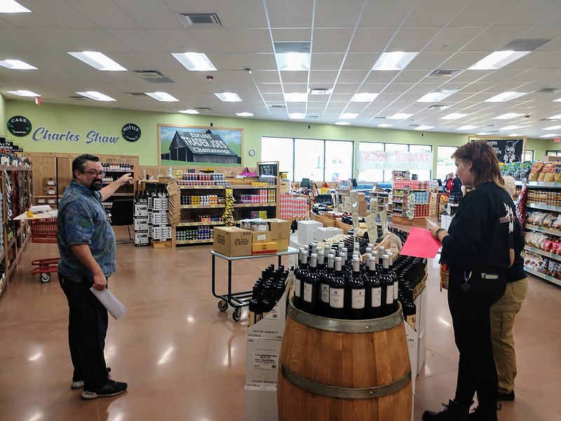 Staff photo by Mike Pare / Noah Stevens, left, is the "captain" at the new Trader Joe's store on Gunbarrel Road. He and other employees prepare for the store's grand opening on Wednesday.