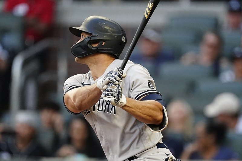 New York Yankees' Giancarlo Stanton follows though on a solo home run in the second during a baseball game against the Atlanta Braves, Monday, Aug. 23, 2021, in Atlanta. (AP Photo/John Bazemore)