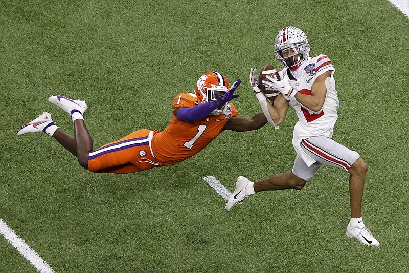 FILE - Ohio State wide receiver Chris Olave catches a touchdown pass in front of Clemson cornerback Derion Kendrick during the second half of the Sugar Bowl NCAA college football game in New Orleans, in this Friday, Jan. 1, 2021, file photo. Olave was selected to The Associated Press Preseason All-America first team offense, Monday Aug. 23, 2021. (AP Photo/Butch Dill, File)