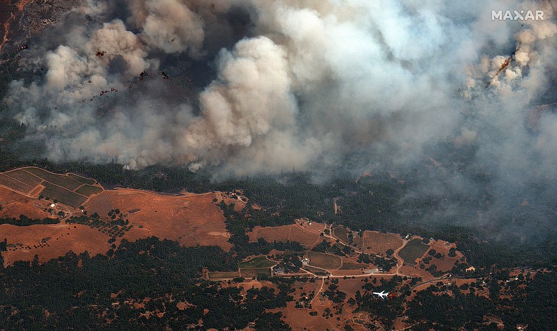 Satellite Image ©2021 Maxar Technologies via AP / In this satellite image provided by Maxar Technologies, an air tanker, bottom right, flights near active fire lines of the Caldor Fire, burning east of Sacramento, Calif., on Wednesday, Aug. 25, 2021.
