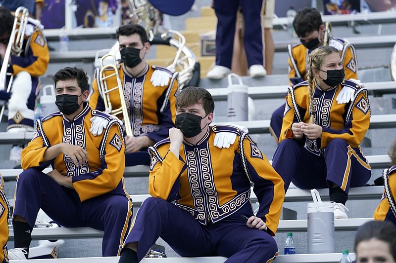 FILE - In this Sept. 26, 2020, file photo, members of the LSU marching band, wearing mask, sit socially distanced from one another due to COVID-19 restrictions before an NCAA college football game between the LSU and the Mississippi State in Baton Rouge, La. Louisiana State University students will have to wear masks in classrooms and at campus events this fall to help fight the spread of COVID-19, but won't have to be vaccinated to return to school, university officials announced Wednesday, Aug. 4, 2021. (AP Photo/Gerald Herbert, File)


