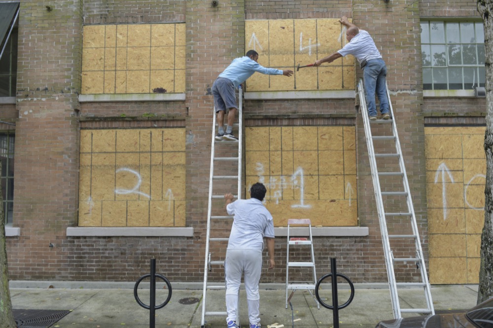 A crew covers windows along Julia St. in the Central Business District as Hurricane Ida approaches the Louisiana coast in New Orleans, La. Saturday, Aug. 28, 2021. ( Max Becherer, NOLA.com, The Times-Picayune/The New Orleans Advocate via AP)
