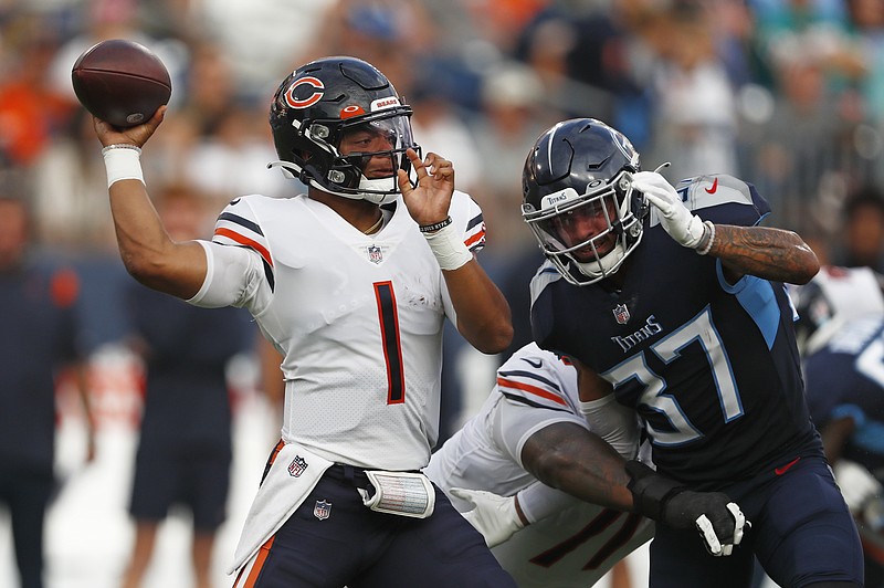 AP photo by Wade Payne / Chicago Bears quarterback Justin Fields passes under pressure from Tennessee Titans safety Amani Hooker during the first half of an NFL preseason game Saturday night in Nashville.