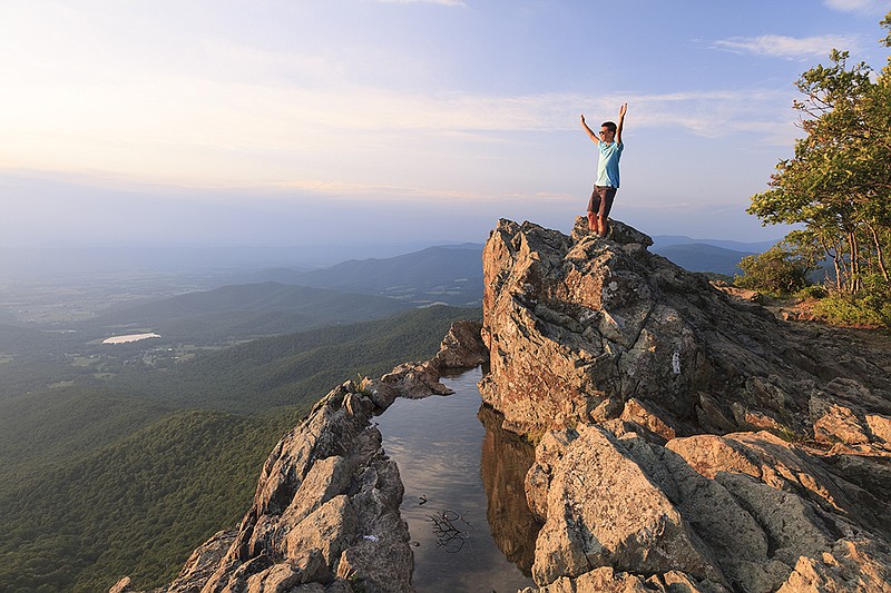 Getty Images / A man stands on Little Stony Man mountain overlooking the Blue Ridge Mountains in the Shenandoah National Park.