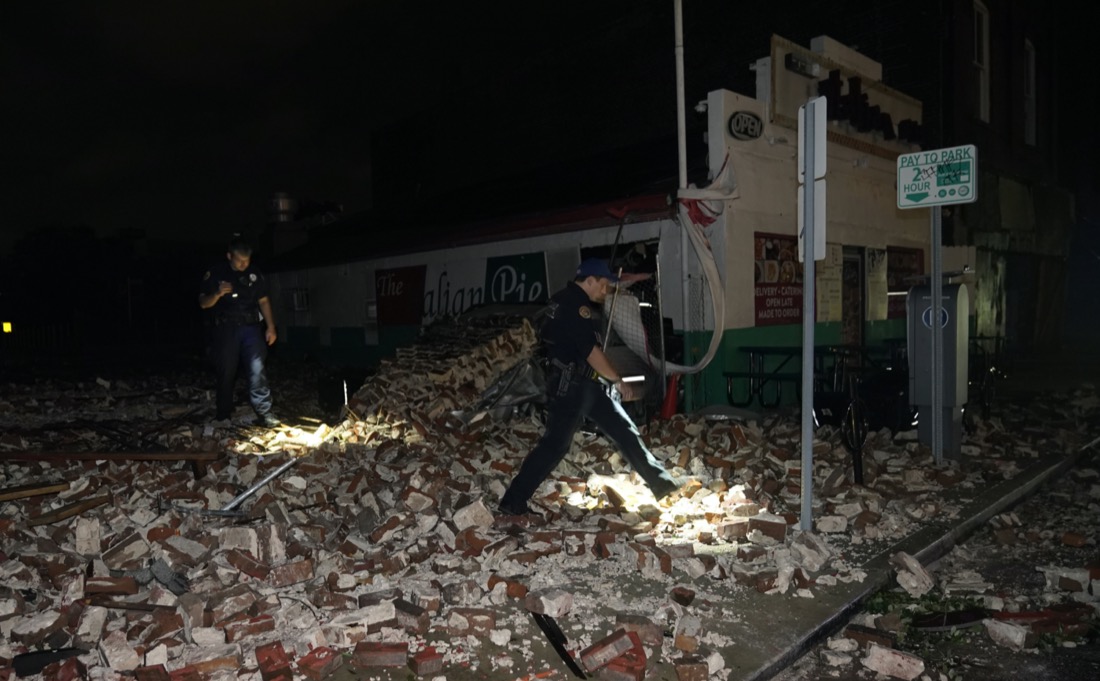 New Orleans Police detective Alexander Reiter, looks over debris from a building that collapsed during Hurricane Ida in New Orleans, Monday, Aug. 30, 2021. Hurricane Ida knocked out power to all of New Orleans and inundated coastal Louisiana communities on a deadly path through the Gulf Coast that is still unfolding and promises more destruction. (AP Photo/Gerald Herbert)