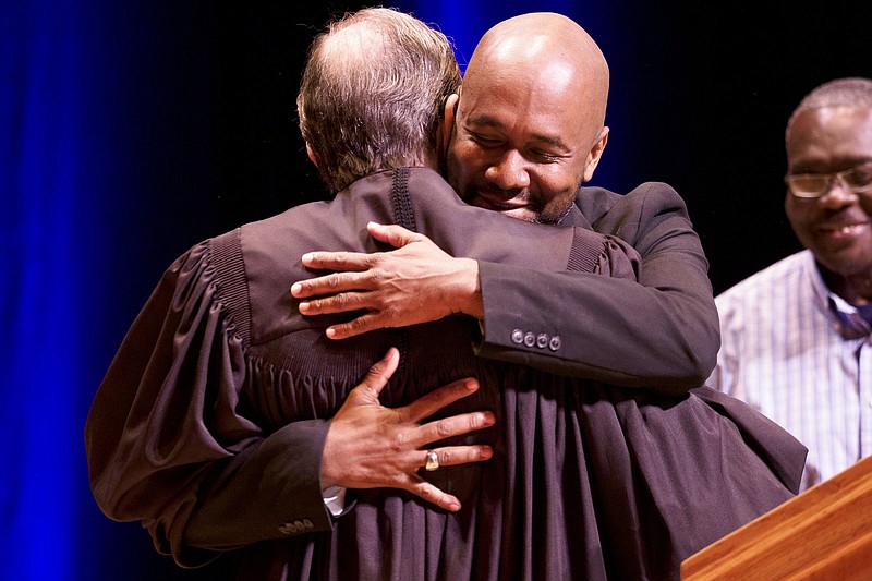 Staff File Photo / Chattanooga City Councilman Anthony Byrd, hugging Judge Clarence Shattuck after being sworn in for a second term earlier his year, based his vaccine hesitation on a shameful government experiment on a group of black men in Alabama that ended nearly 50 years ago.