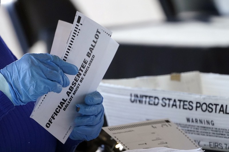 FILE - A worker at the Fulton County Board of Registration and Elections works to process absentee ballots at the State Farm Arena Monday, Nov. 2, 2020, in Atlanta. (AP Photo/John Bazemore, File)


