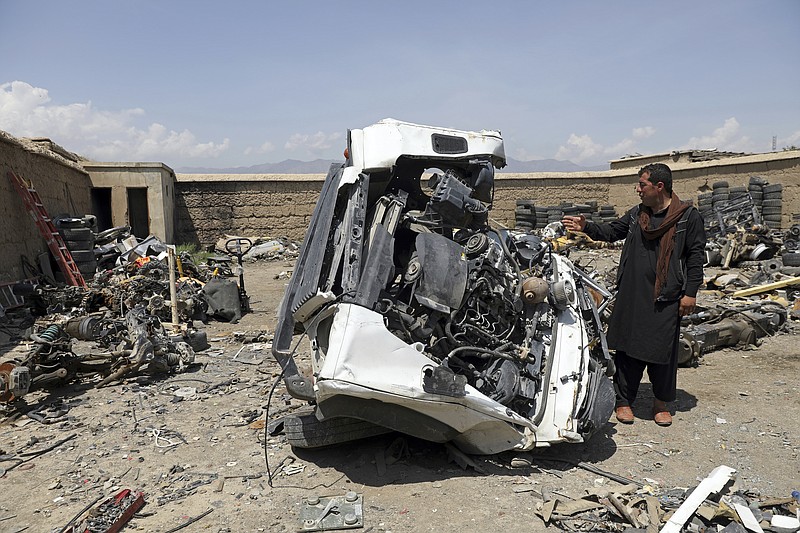 AP Photo/ Rahmat Gul / An Afghan man looks at a damaged vehicles in Baba Mir's scrapyard outside Bagram Air Base, northwest of the capital Kabul, Afghanistan, earlier this year.
