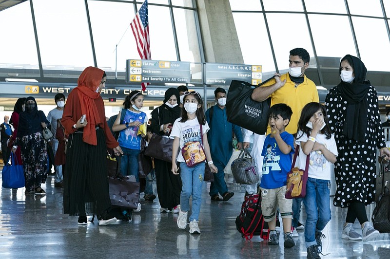 Families evacuated from Kabul, Afghanistan, walk through the terminal before boarding a bus after they arrived at Washington Dulles International Airport, in Chantilly, Va., on Thursday, Sept. 2, 2021. (AP Photo/Jose Luis Magana)


