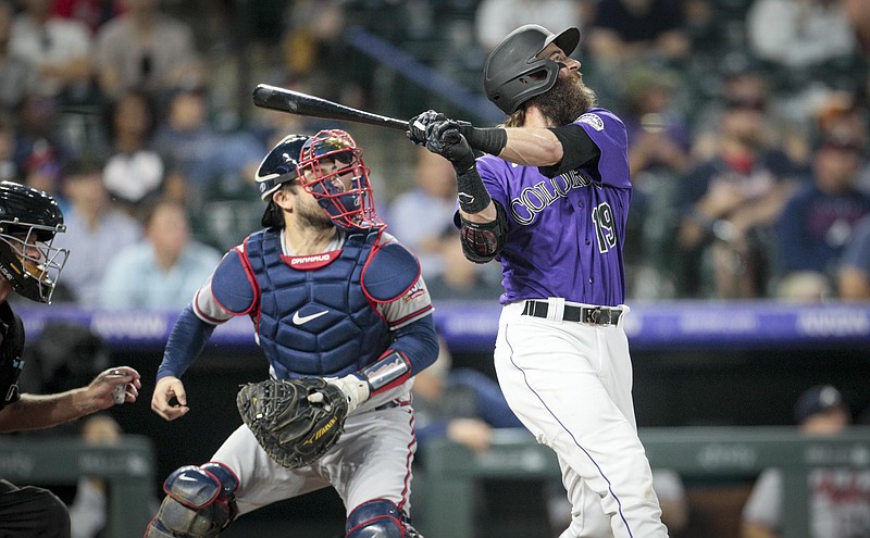 AP photo by Joe Mahoney / Colorado Rockies right fielder Charlie Blackmon hits a sacrifice fly that scored two runs as Atlanta Braves catcher Travis d'Arnaud watches in the third inning of Friday night's game in Denver.