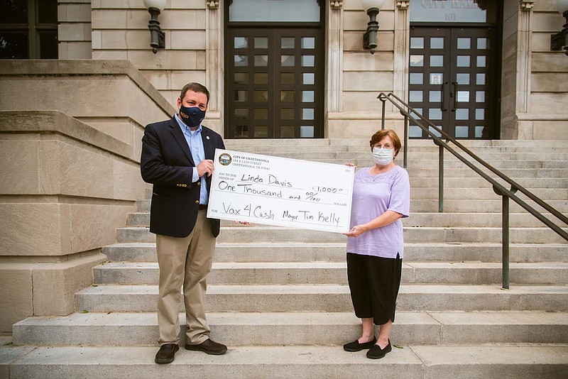 Contributed photo by the city of Chattanooga / Linda Davis, right, accepts a $1,000 check from Chattanooga Mayor Tim Kelly's chief of staff, Brent Goldberg.