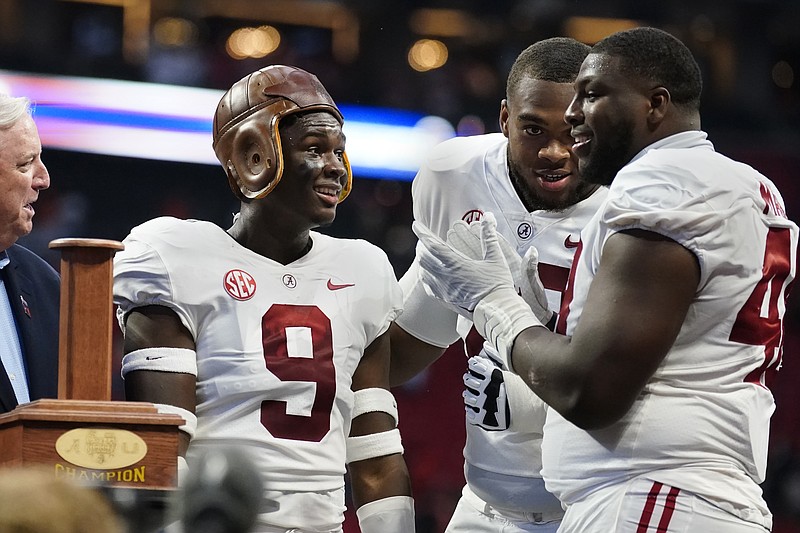 AP photo by John Bazemore / Alabama quarterback Bryce Young (9) wears the leather helmet from the Chick-fil-A Kickoff Game trophy as he celebrates with teammates Phidarian Mathis, right, and Evan Neal after Saturday's win against Miami in Atlanta.