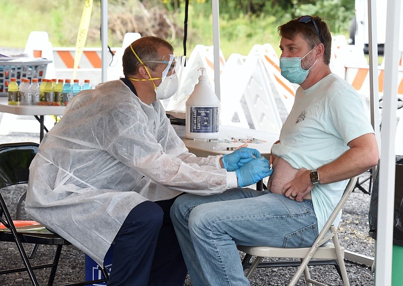 Staff Photo by Matt Hamilton / Dalton Fire Department paramedic Michael Sams injects the monoclonal antibody treatment into the abdomen of Cartersville resident Mitch Lowery on Wednesday. The Regeneron clinic provided the monoclonal antibody treatment in a drive-thru setting at the Dalton Convention Center parking lot on Wednesday, September 1, 2021.