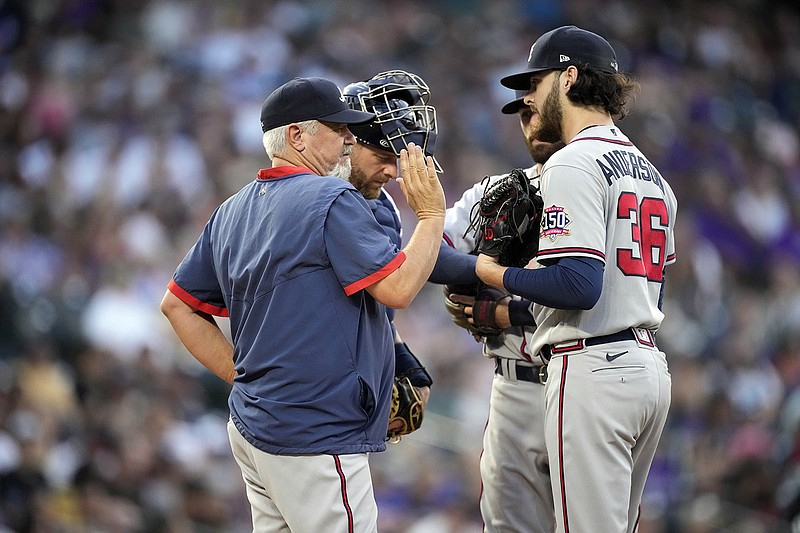 AP photo by Davis Zalubowski / Atlanta Braves pitching coach Rick Kranitz, left front, confers with starter Ian Anderson, right front, after he walked Elias Diaz during the second inning of Saturday night's game against the Colorado Rockies in Denver. Braves catcher Stephen Vogt, back left, and shortstop Dansby Swanson, back right, listen in.